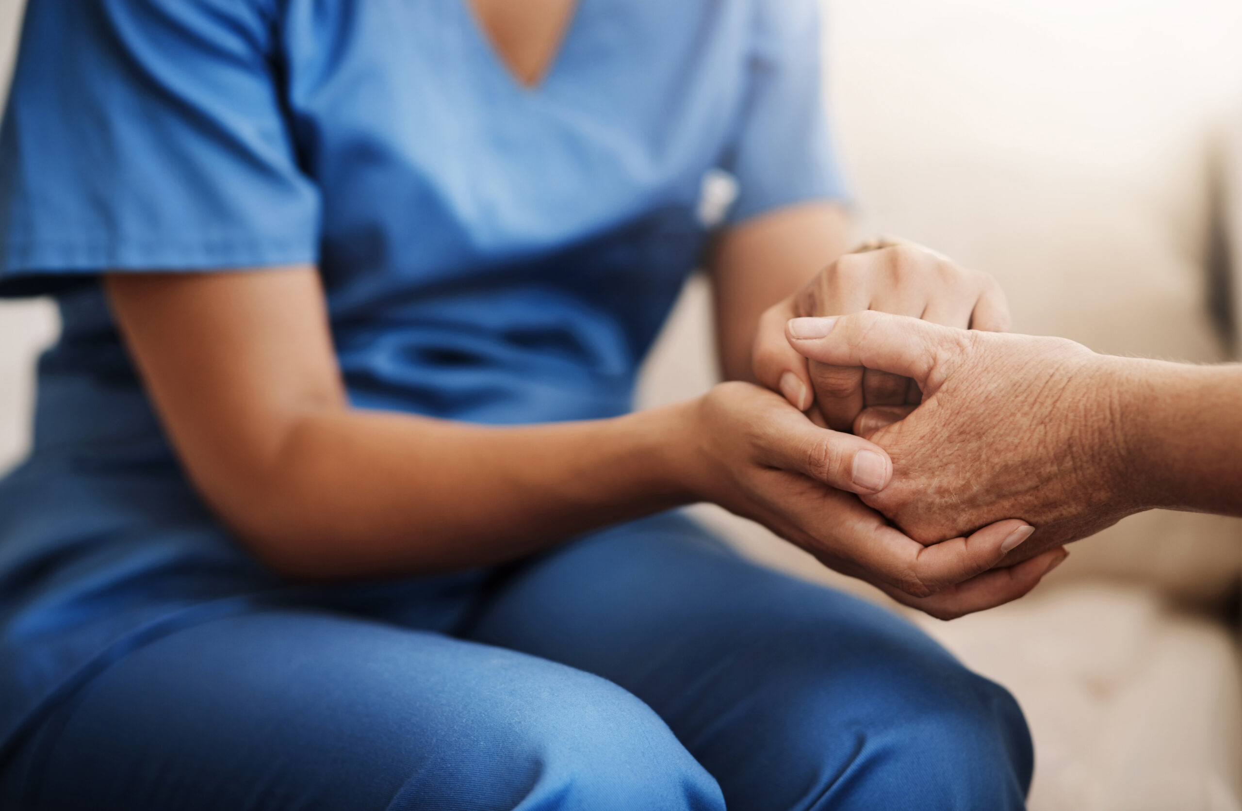 Caregiver, support and senior woman holding hands on sofa for health, consulting or compassion. Help, nurse and elderly patient with care for hope, trust or medical conversation at retirement home.